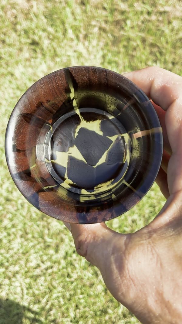 Inside a dark walnut and gold resin tumbler